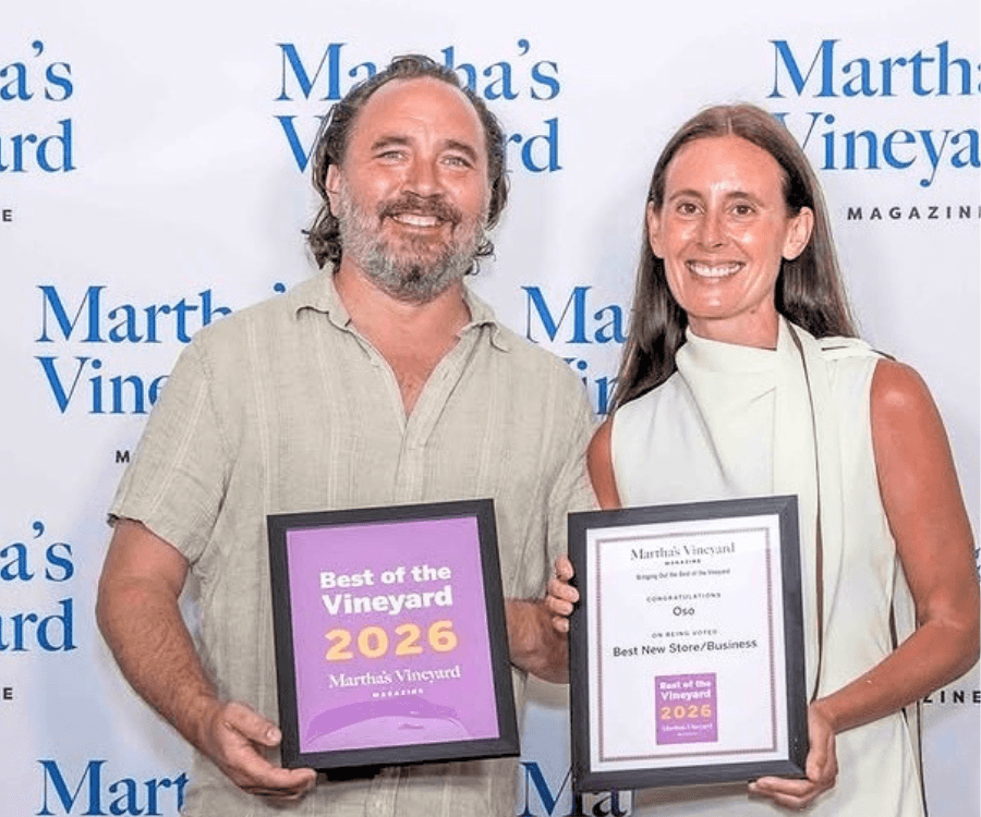 Two people hold award plaques in front of a "Martha's Vineyard" backdrop.
